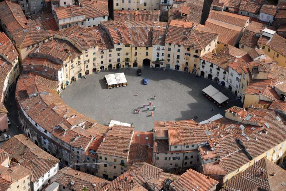 Piazza dell'Anfiteatro, Lucca. Le case sono costruite sugli antichi spalti, mentre gli affacci sulla piazza seguono ancora l'andamento delle arcate di accesso all'arena.